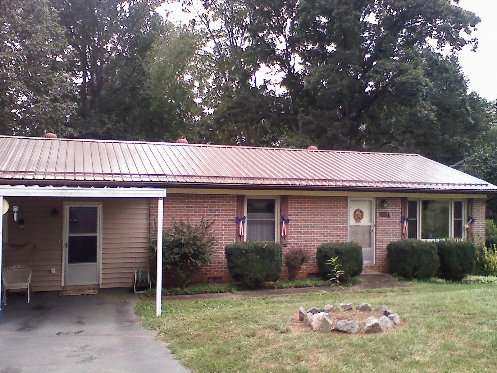 Bronze metal roof and carport on a brick ranch home — Roof Repair work by our crew in Bloomington